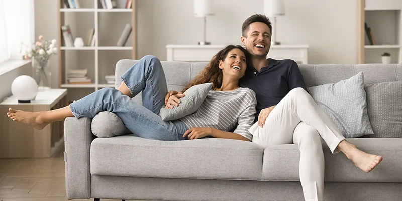 uomo e donna gioiosi sul divano